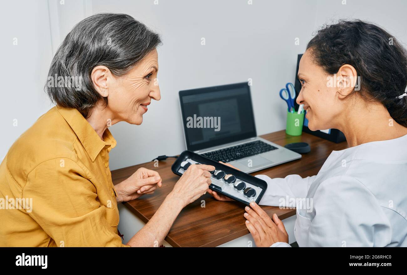 Selections of hearing aids. Hearing aids for a mature woman to treat hearing loss Stock Photo