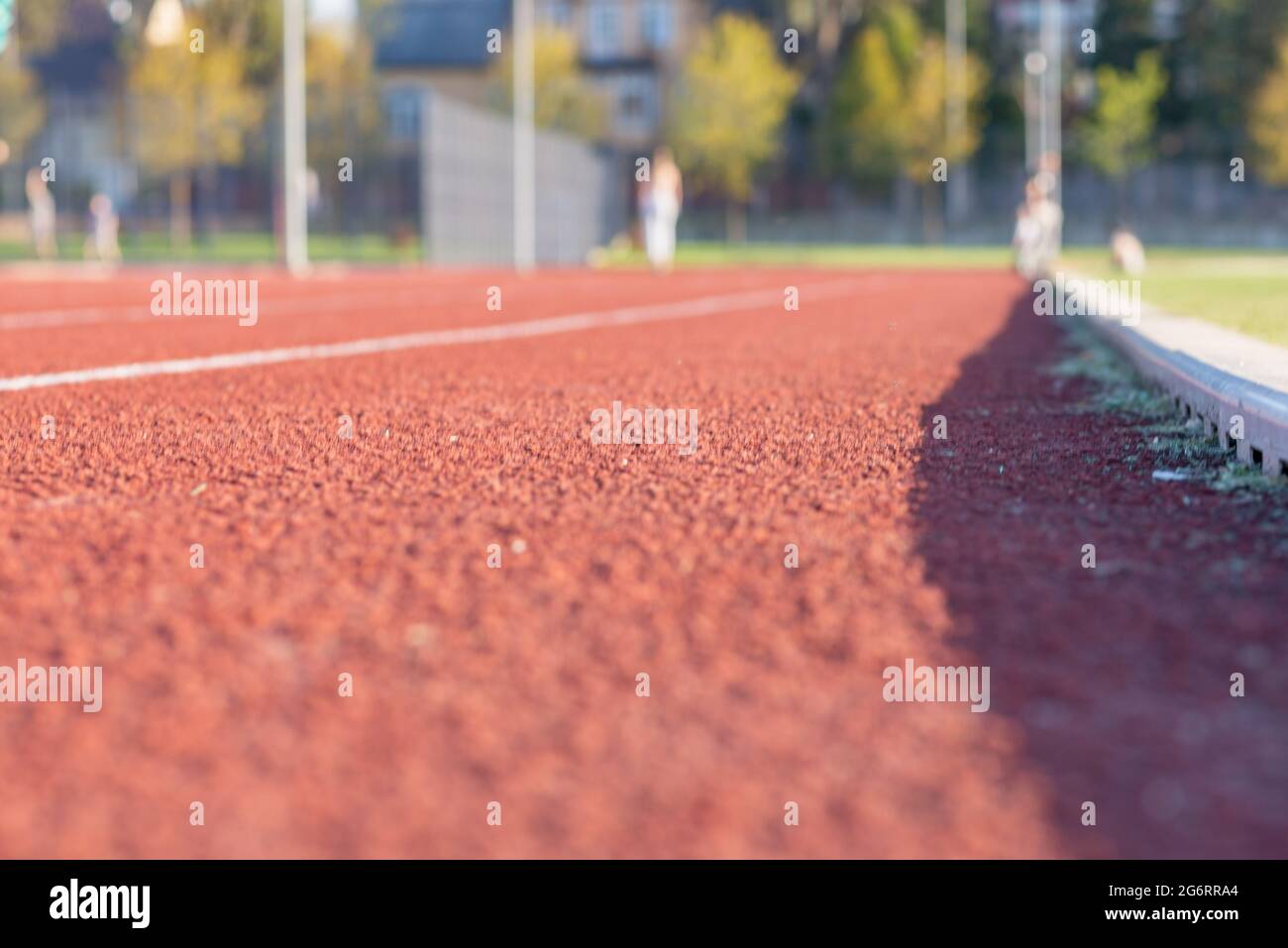 Red plastic track in the outdoor track and field stadium.Closeup. Stock Photo