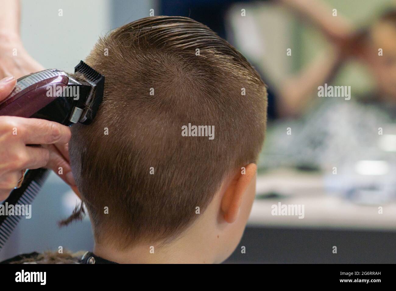 Cute kid boy have hair cut, professional barber doing haircut. Hairdress  for children. Kid side view portraits in the  view Stock  Photo - Alamy