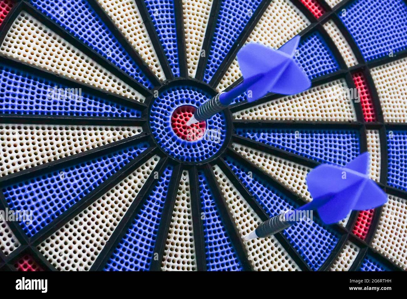 Darts is a sport in which small arrows/darts are thrown at a circular  dartboard fixed to a wall. One dart succeeded to hit bulls-eye,centre of  the boa Stock Photo - Alamy