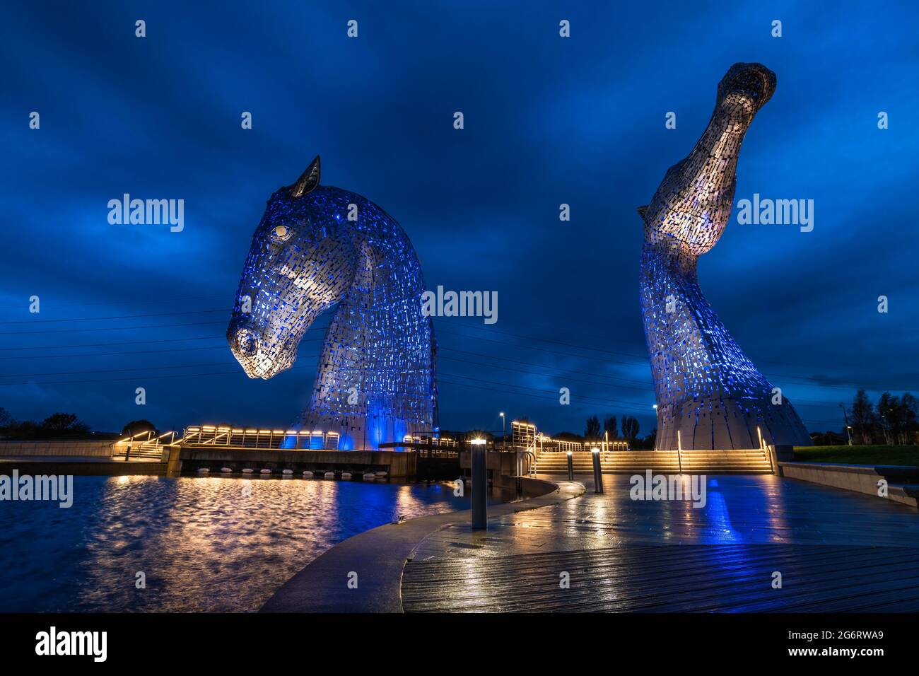 A dark, wet, raining autumnal evening photographing the lit up steel horse head sculptures created by Andy Scott. Stock Photo