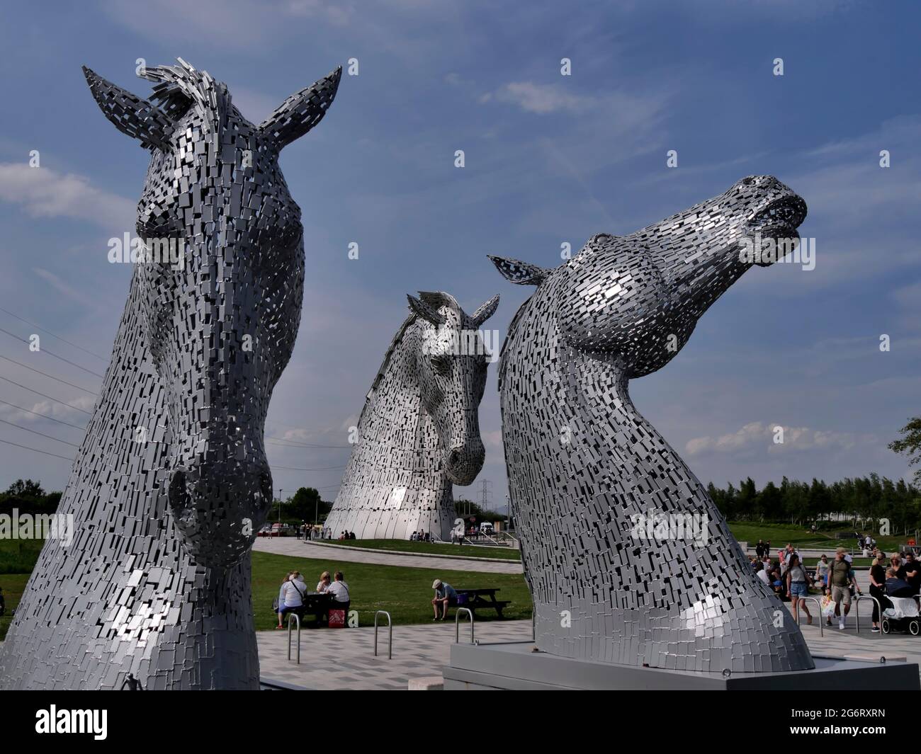 an unusual view of 3 kelpies as the Kelpie Maquettes frame one of the full size Kelpies, horse-head sculptures by Artist  Andy Scott, Falkirk,Scotland Stock Photo