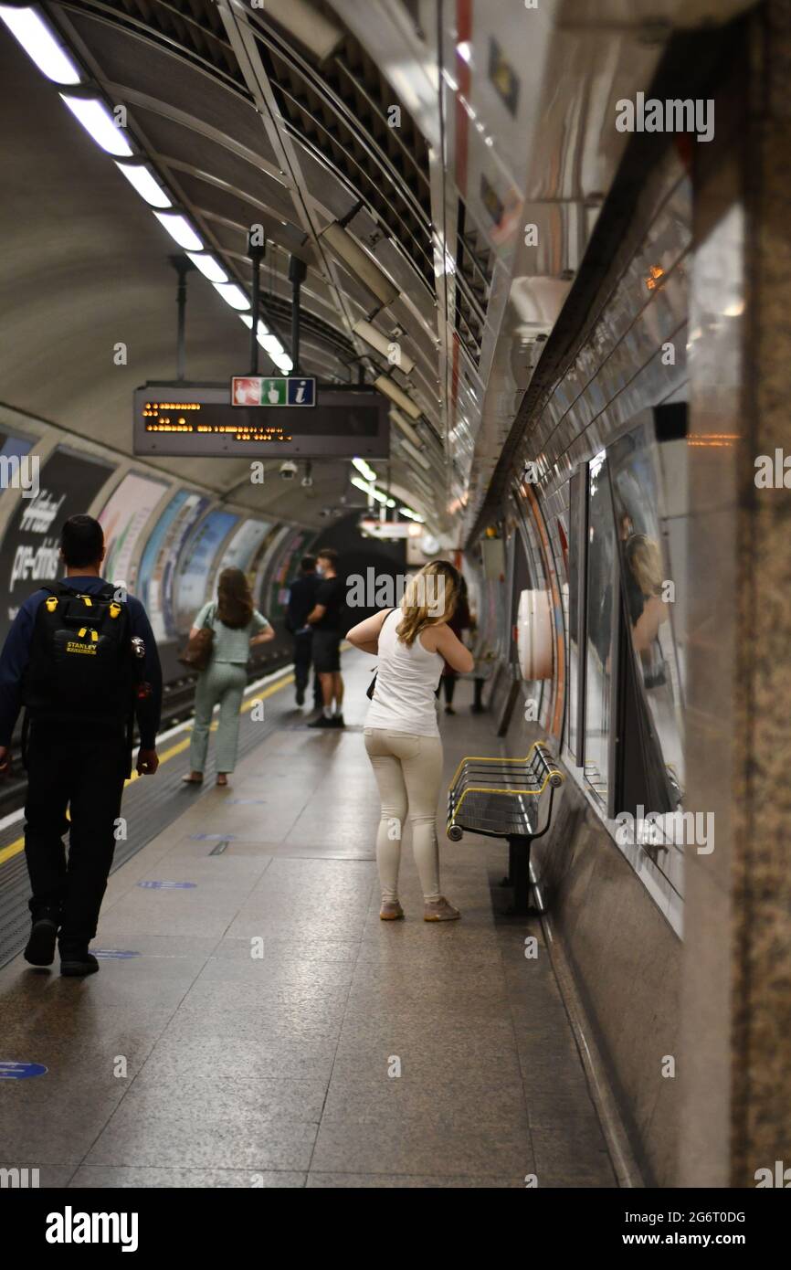 People waiting on the platform for a tube train at St Paul's tube station in July 2021 Stock Photo