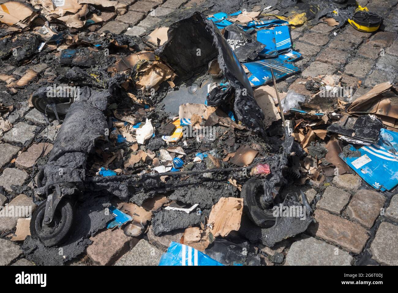 Abgebrannter Müll-Container mit Adidas-Schachteln Stock Photo