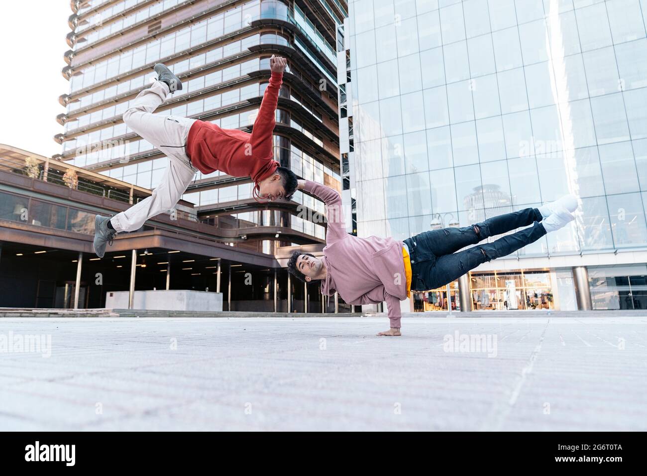 Talented young boys doing break dance in the street and having fun. They are doing coordinated moves. Stock Photo