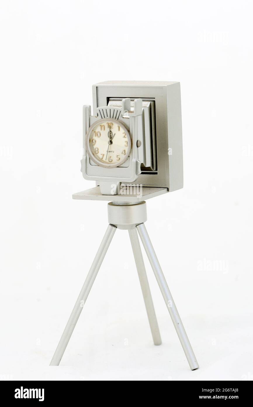 Collectable theme based on photographers and photographers. Silver camera on tripod with clock face Stock Photo