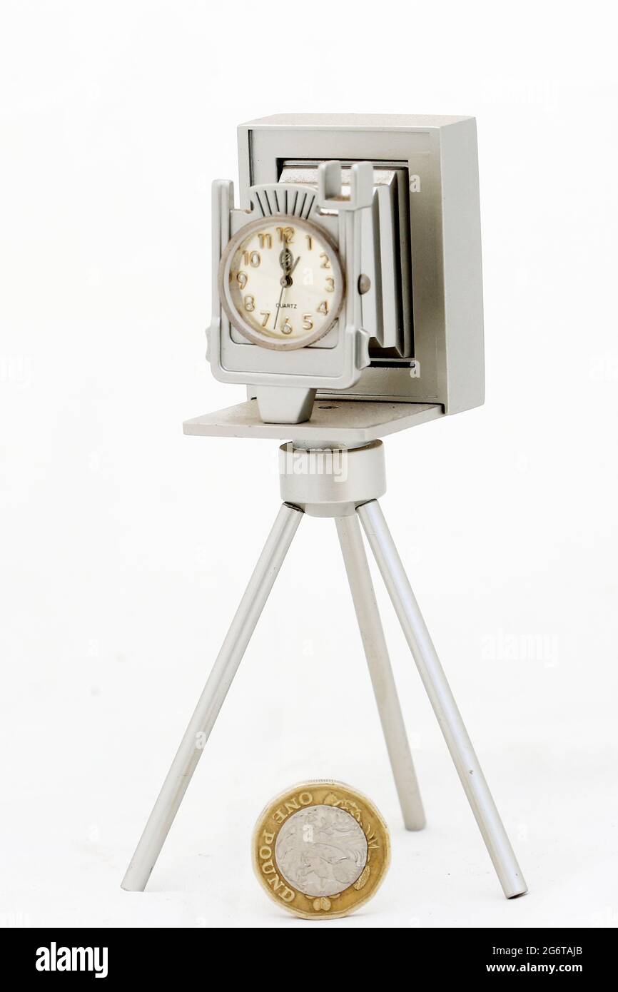 Collectable theme based on photographers and photographers. Silver camera on tripod with clock face Stock Photo