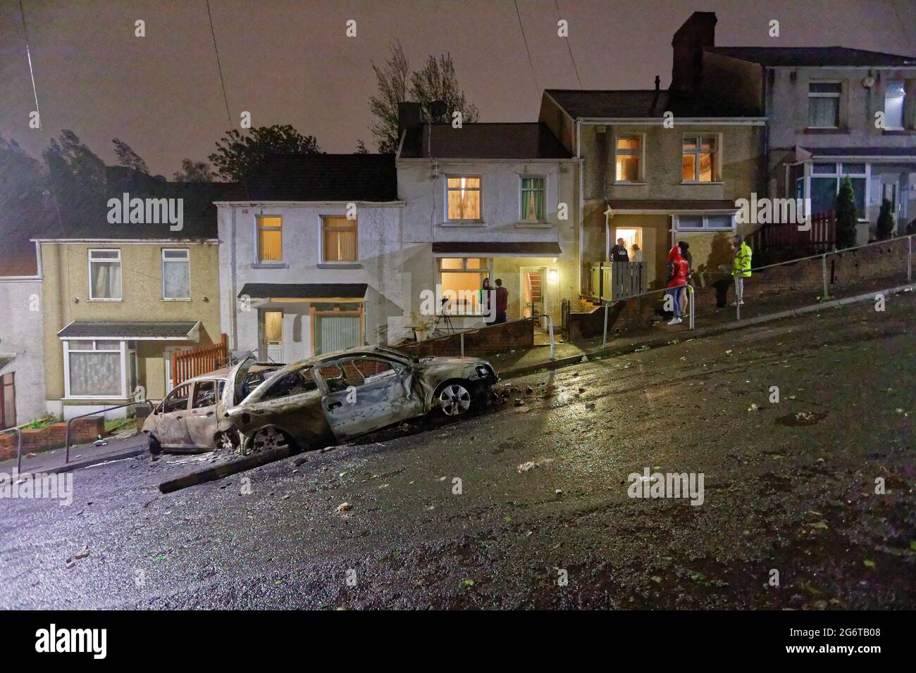 Pictured: Two of the burned out cars outside the house of Adam Romain in Waun-Wen Road in the Mayhill area of Swansea, Wales, UK. Thursday 20 May 2021 Stock Photo