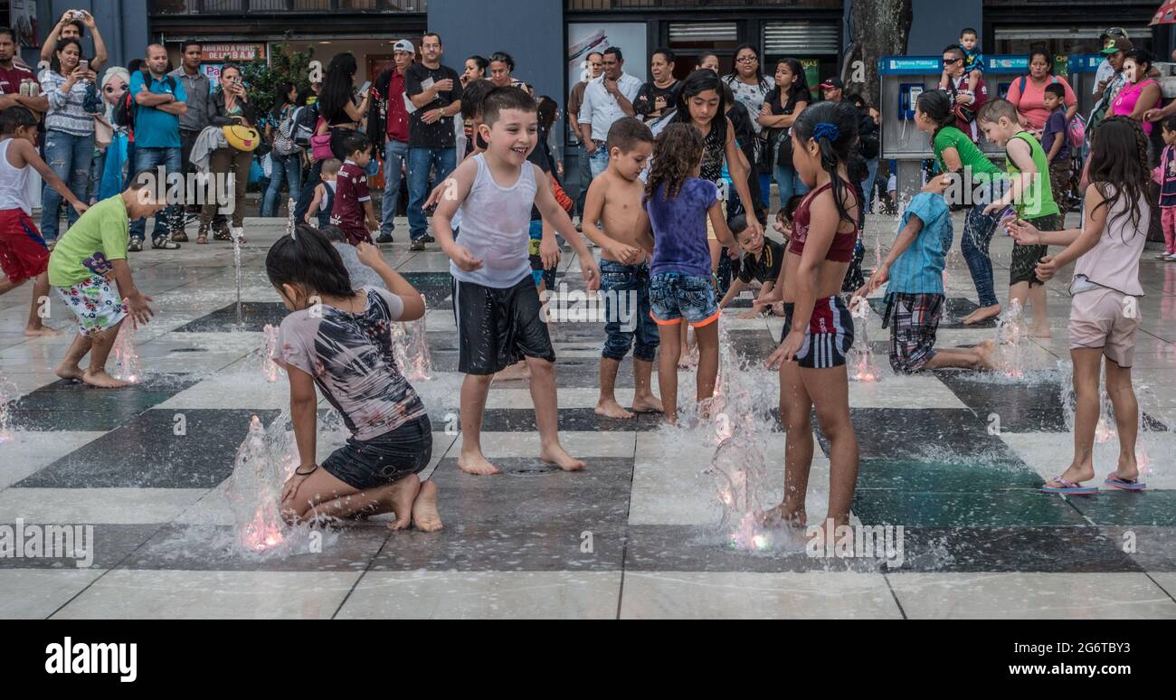 Kids playing in water fountains in San Jose, Costa Rica. Stock Photo