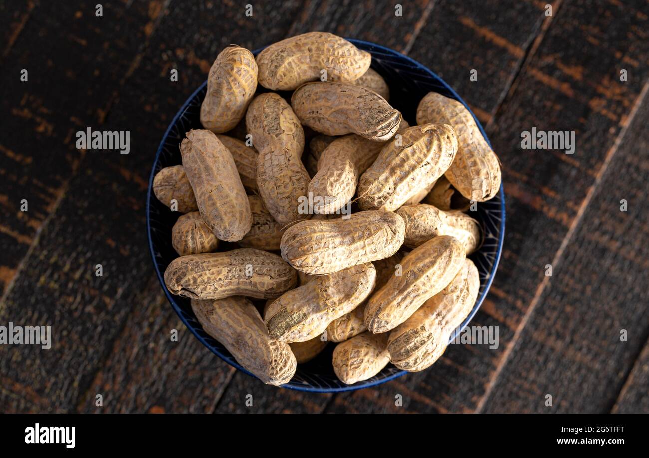 Raw In Shell Peanuts on a Rustic Wooden Kitchen Table Stock Photo