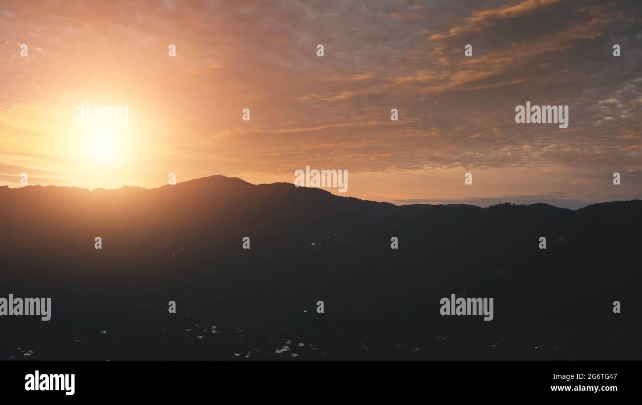 Mountain silhouette at sunset aerial. Nobody nature landscape at sun set. Countryside town at mount valley. Twilight village at fir forest. Tourism scenery at Carpathians mounts, Ukraine, Europe Stock Photo