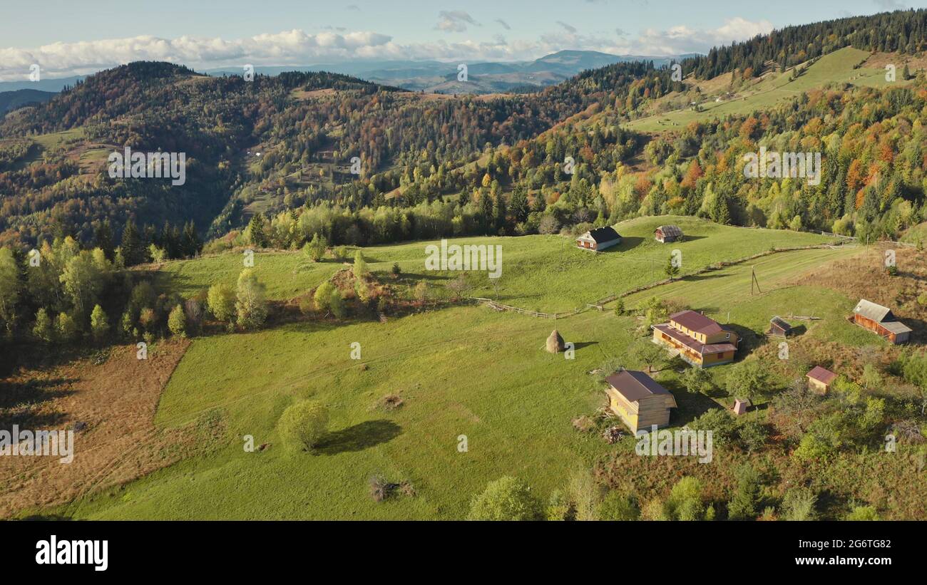 Village at green mountain top aerial. Nobody nature landscape. cottages with rural ways. Cinematic autumn greenery trees, grass. Carpathians mount ranges, Ukraine, Europe. Travel and tourism concept Stock Photo