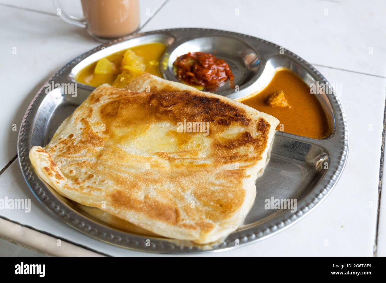 Roti planta is popular breakfast in Malaysia. It is roti canai with added margarine. Stock Photo