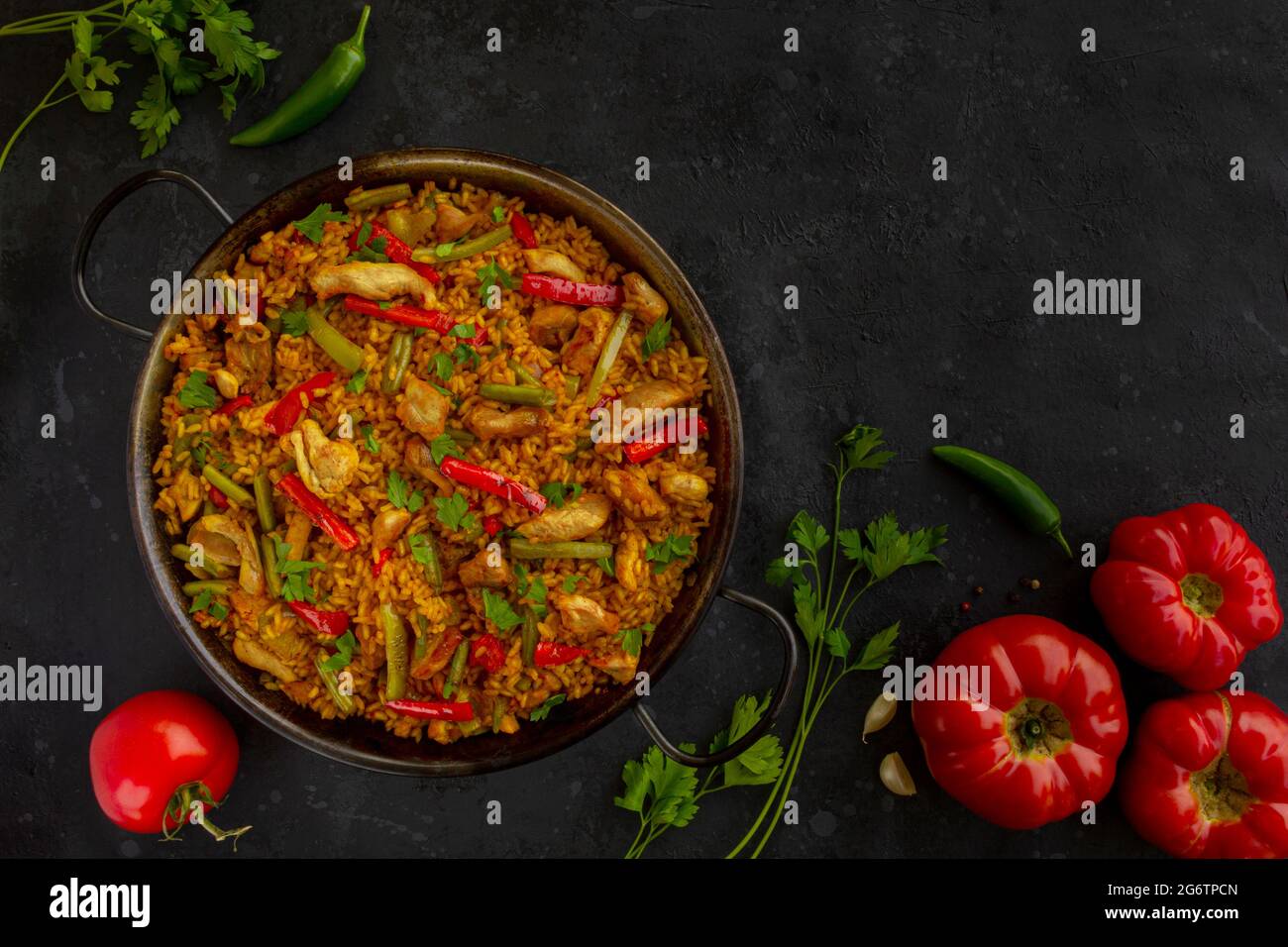 spanish paella rice with chicken on dark background Stock Photo