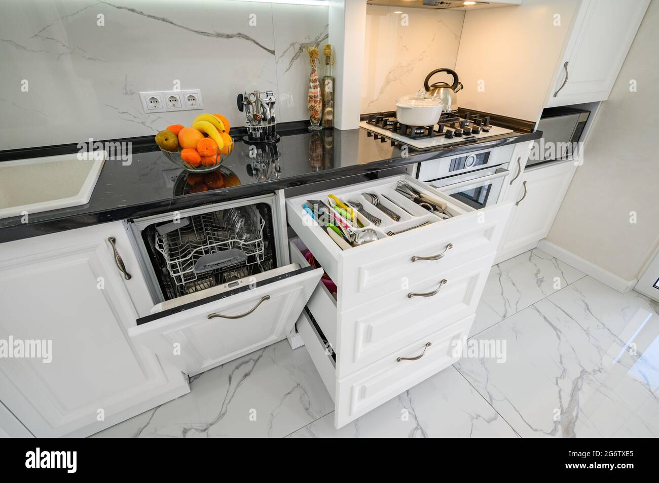 Luxurious white modern kitchen interior, drawers pulled out, dishwasher