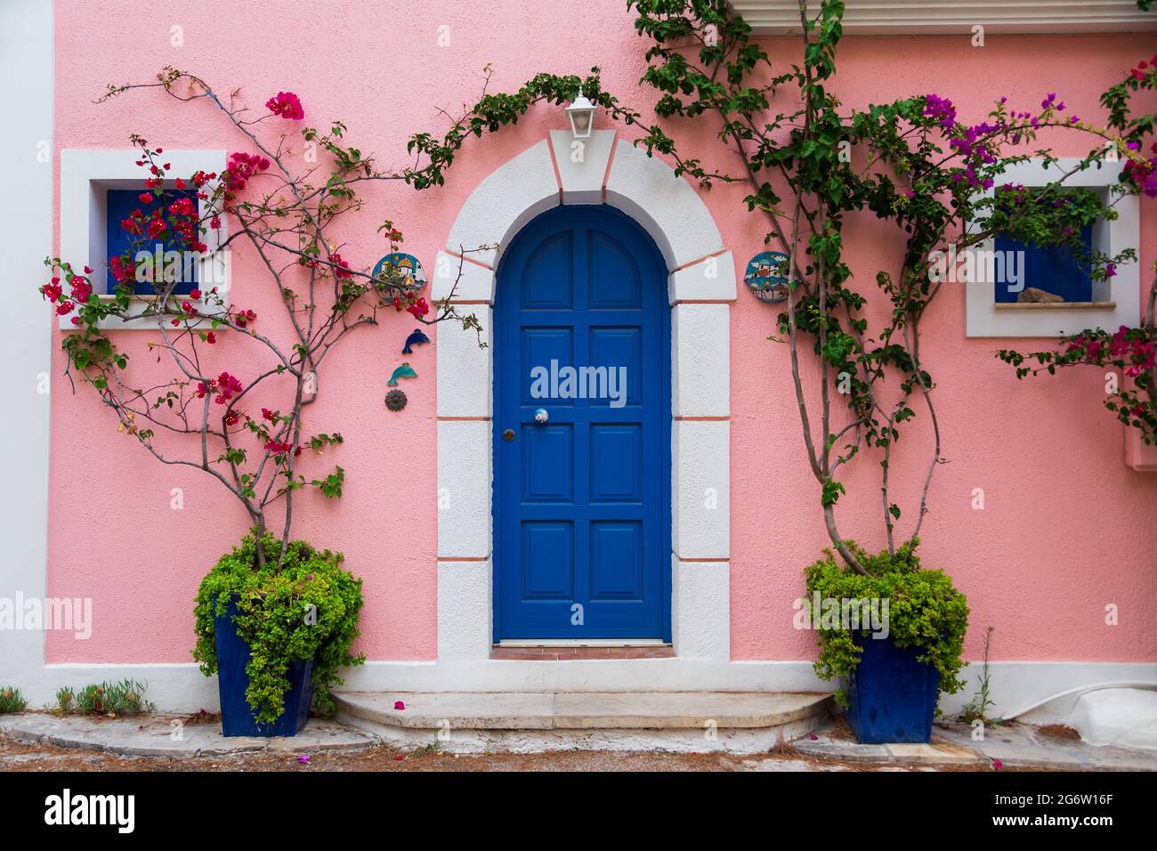 Traditional greek house with colorful blue door and pink walls at Asos village. Assos peninsula famous and extremely popular travel destination in Stock Photo