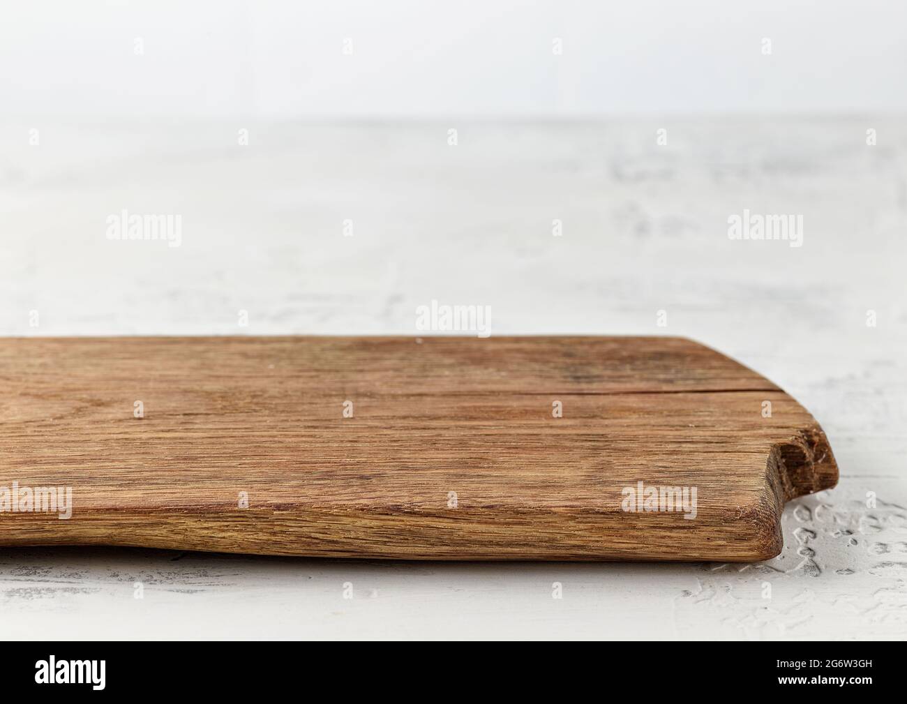 old empty wooden cutting board on white kitchen table Stock Photo