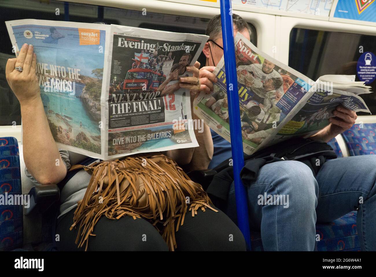 London, UK, 8 July 2021: The England men's football team are through to the EURO 2020 final and dominate the front and back pages of the newspapers, as read by a couple on the London underground. A full page Easyjet advert hopes to lure customers who might take advantage of the relaxation of quarantine rules for Amber List countries from 19 July. Anna Watson/Alamy Live News Stock Photo