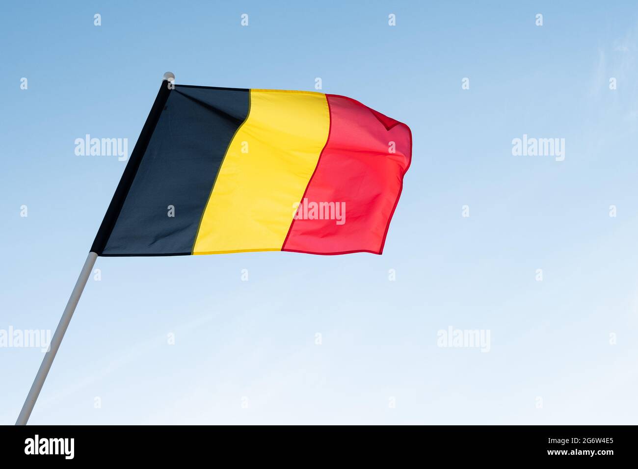 Flag of Belgium on blue sky background. Belgian flag waving in wind Stock Photo