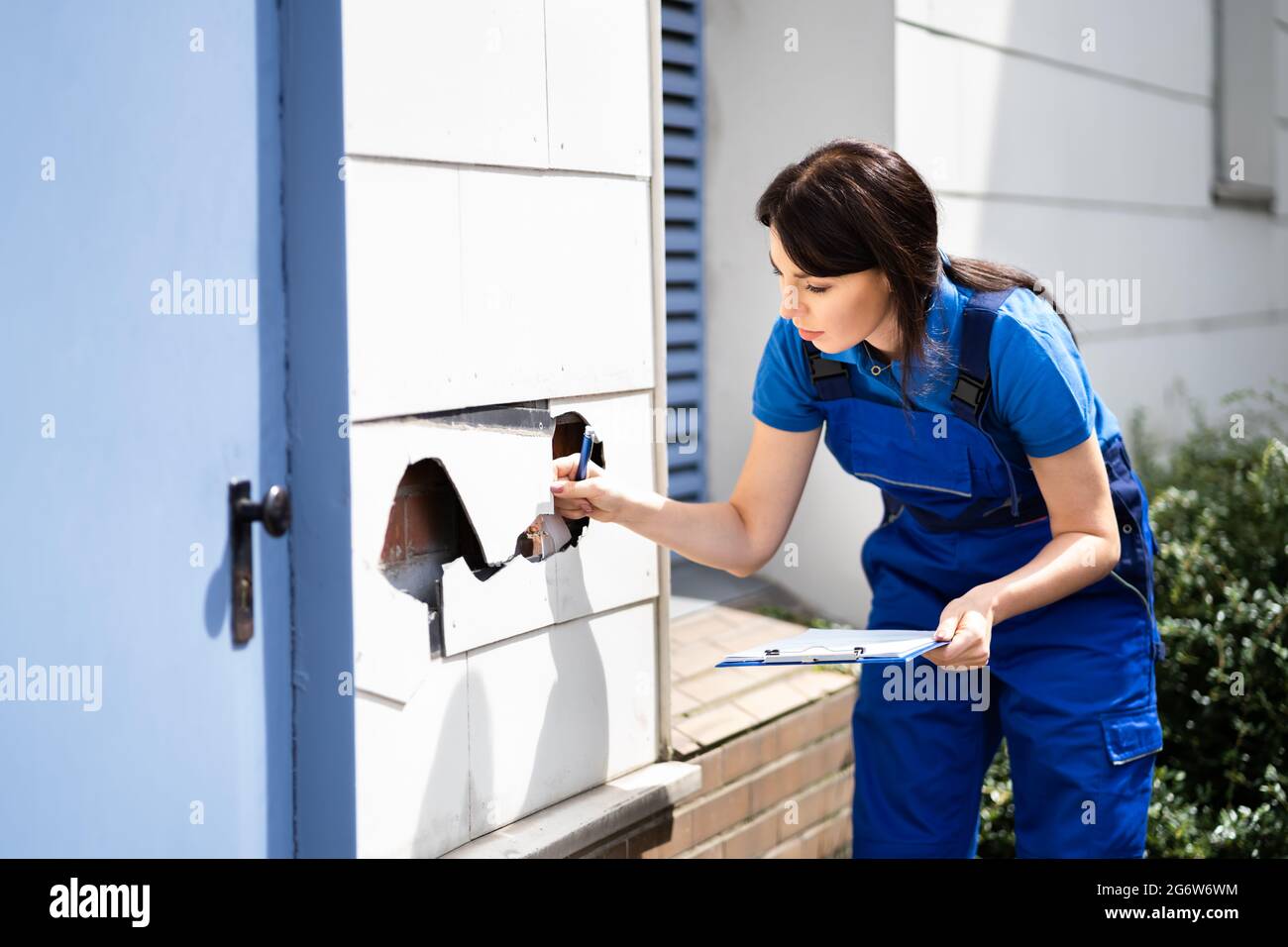 Real Estate Property Appraisal. Woman Inspecting House Stock Photo