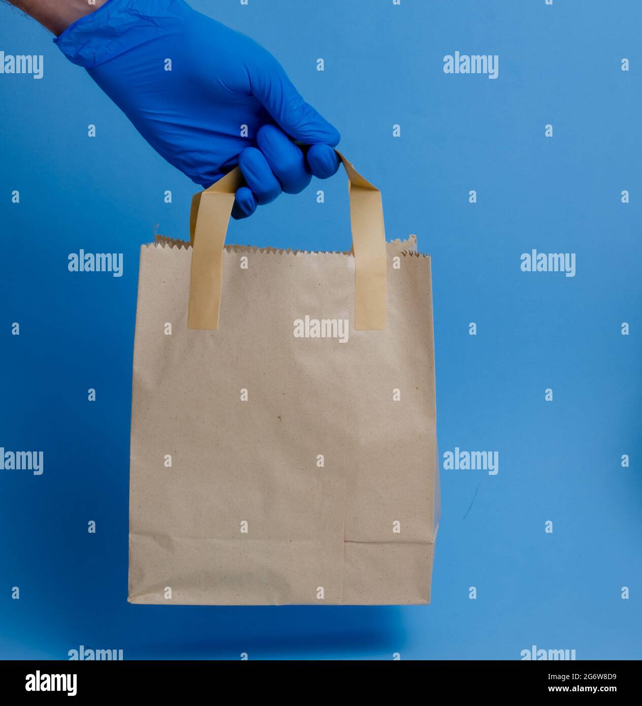 brown paper shopping bag on blue background. Brown empty craft lunch