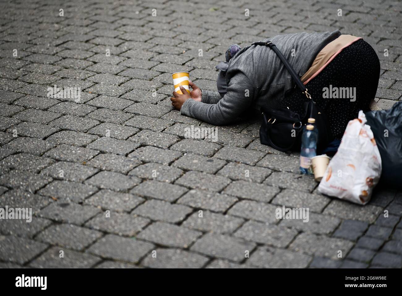 Beggar beg begging on street in pedestrian shopping mile city centre Stock Photo