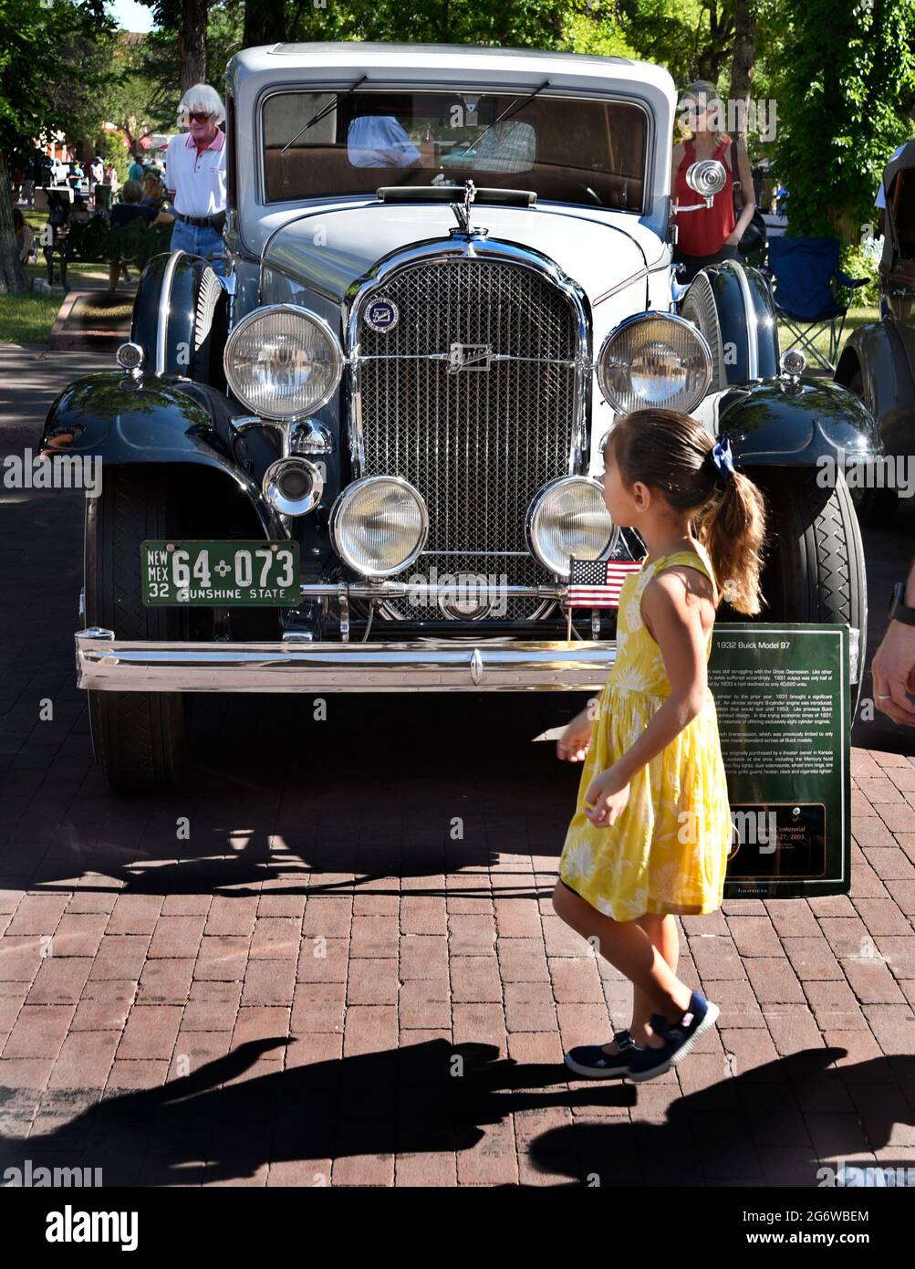A young girl walks in front of a 1932 Buick sedan on dispay at a car show in Santa Fe, New Mexico. Stock Photo