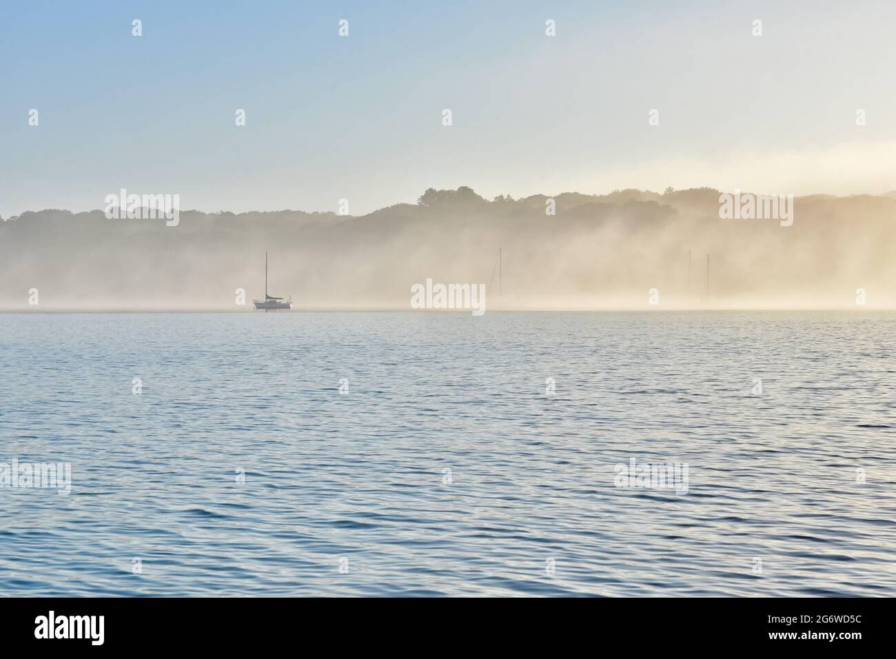 Sailboats in early morning fog in Port Jefferson Harbor, Long Island, NY. Copy space. Stock Photo