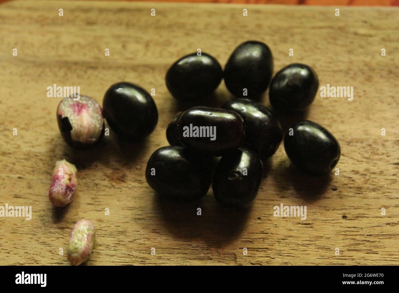 Java plum fruits or syzygium fruit on isolated wooden surface, top view, blue berry fruit, new image Stock Photo
