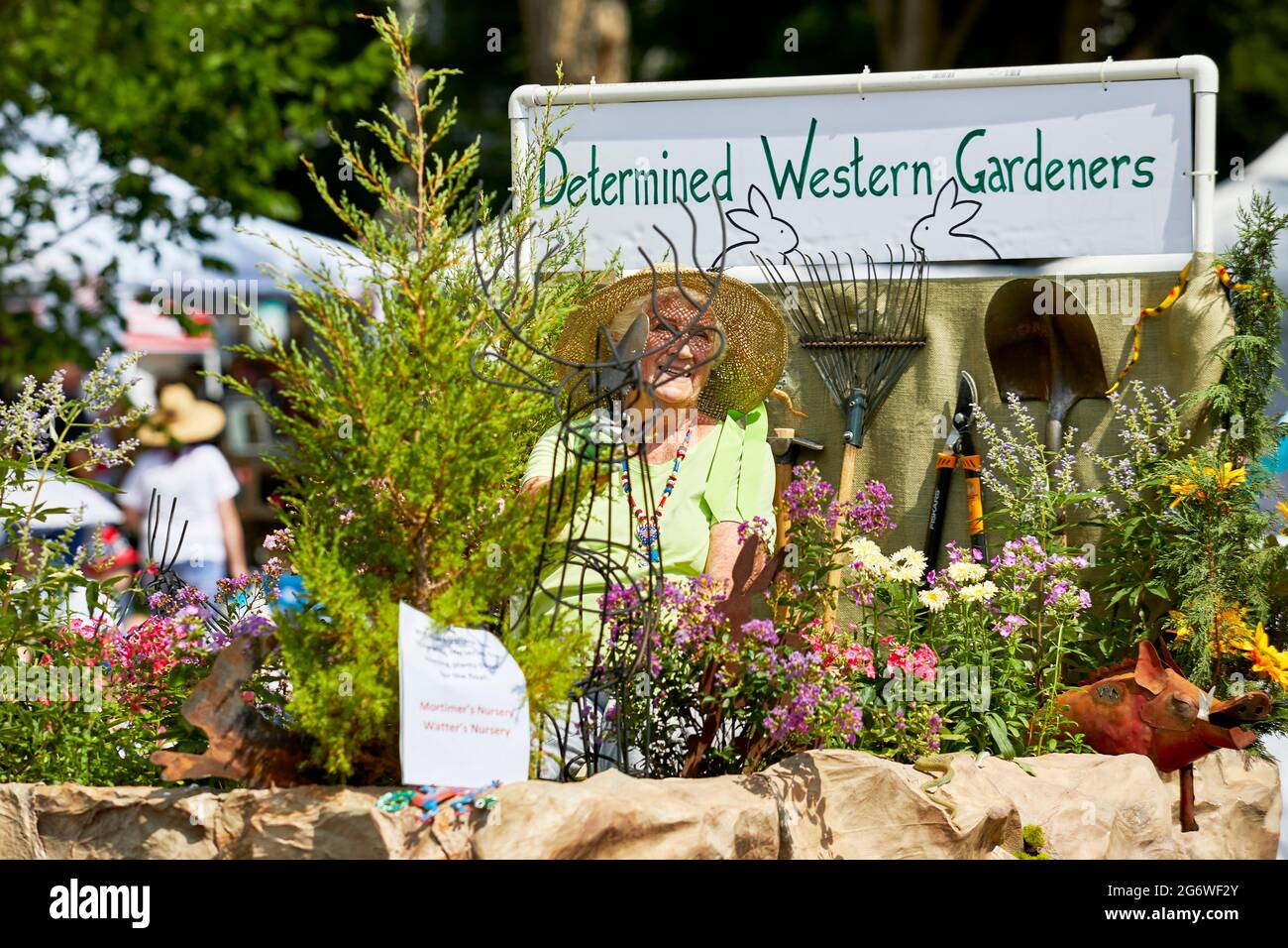 Prescott, Arizona, USA - July 3, 2021: Woman riding on the Determined Western Gardeners float surrounded by plants in 4th of July parade Stock Photo