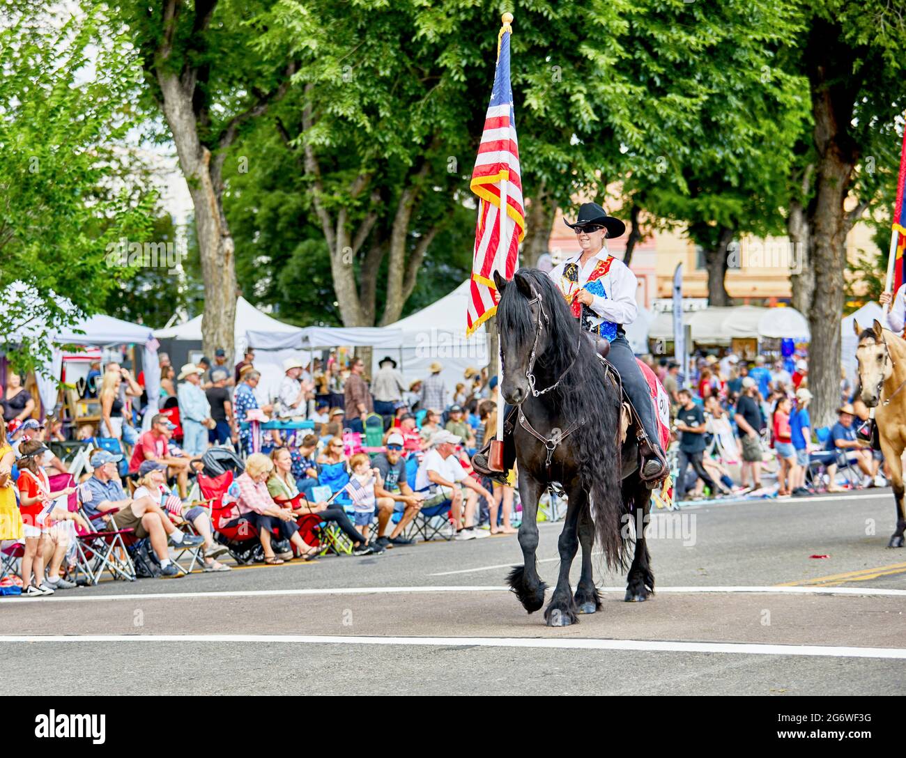 Prescott, Arizona, USA - July 3, 2021: Equestrian rider carrying an American flag while on horseback in the 4th of July parade Stock Photo