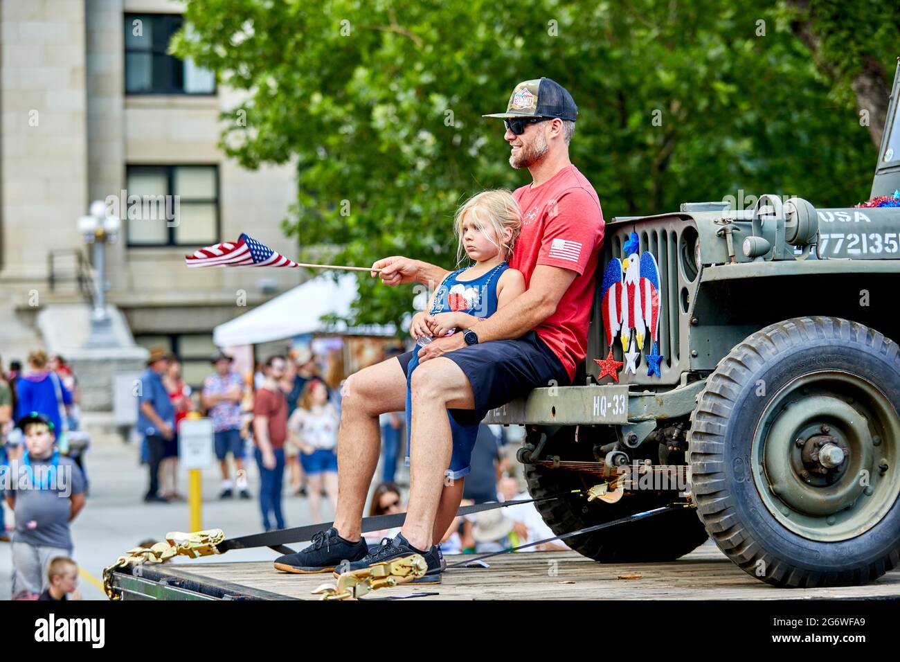 Prescott, Arizona, USA - July 3, 2021: Participants sitting on the front of an old military jeep on a float in the 4th of July parade Stock Photo