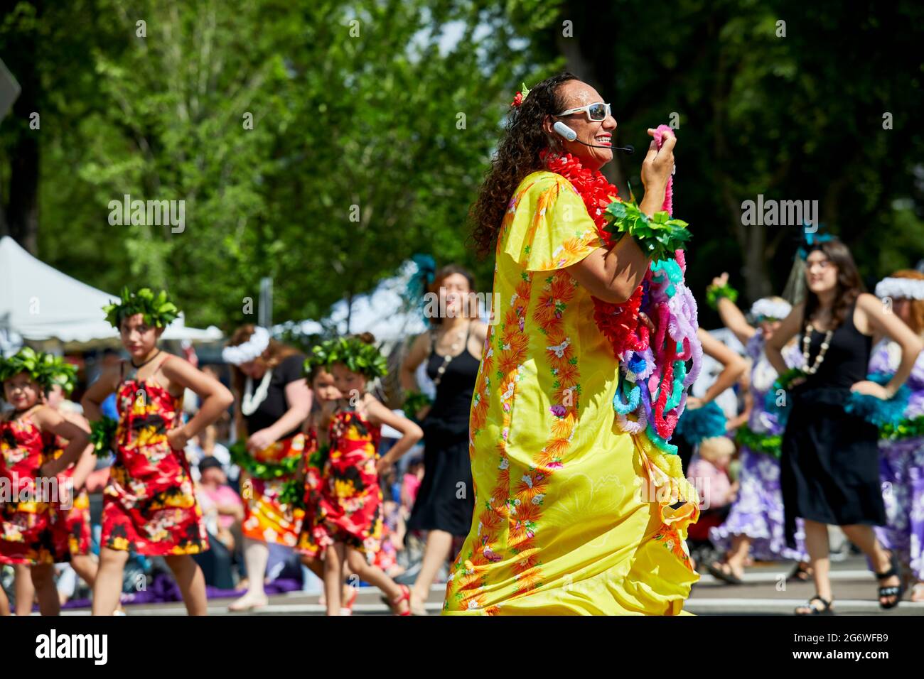 Prescott, Arizona, USA - July 3, 2021: Polynesian hula dancer giving out leis while marching in 4th of July parade Stock Photo