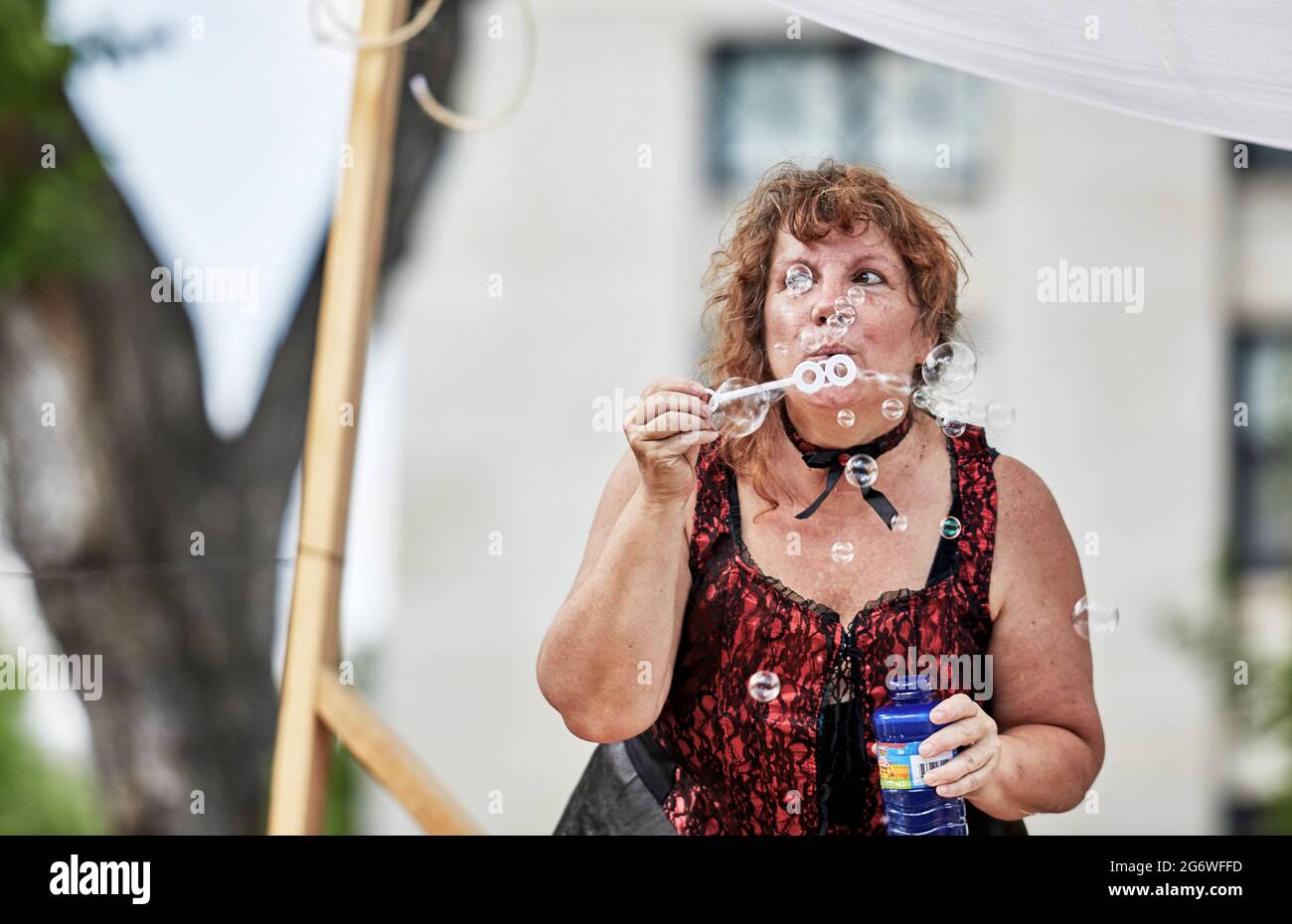 Prescott, Arizona, USA - July 3, 2021: Woman blowing bubbles while riding on a float in the 4th of July parade Stock Photo