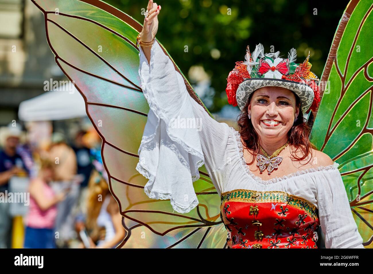 Prescott, Arizona, USA - July 3, 2021: Woman dressed in a butterfly costume with wings waving to the spectators in the 4th of July parade Stock Photo