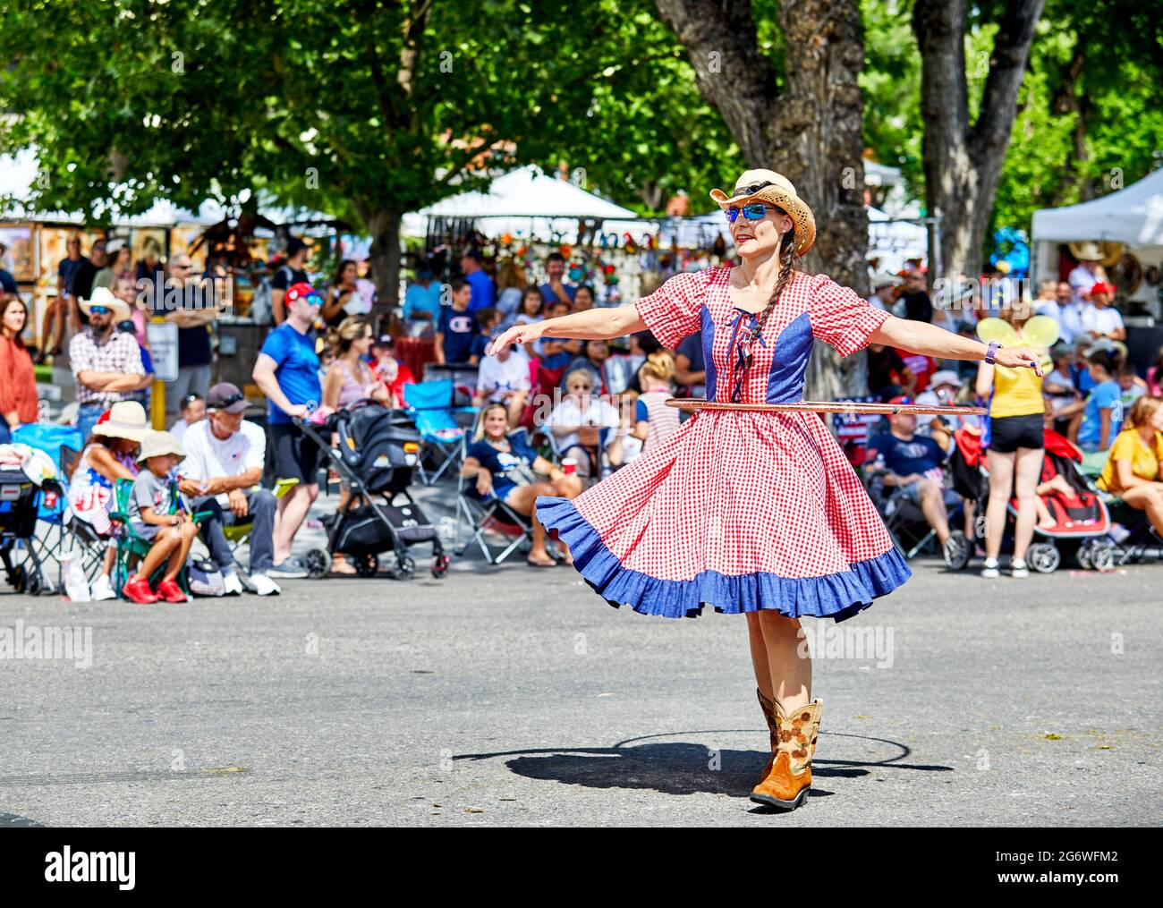 Prescott, Arizona, USA - July 3, 2021: Woman spinning the hula hoop while marching in the 4th of July parade Stock Photo