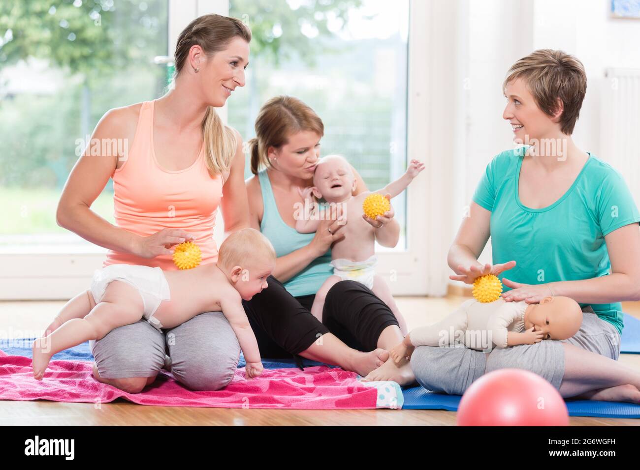 Pregnant Women In Prenatal Class Touching Belly Stock Photo