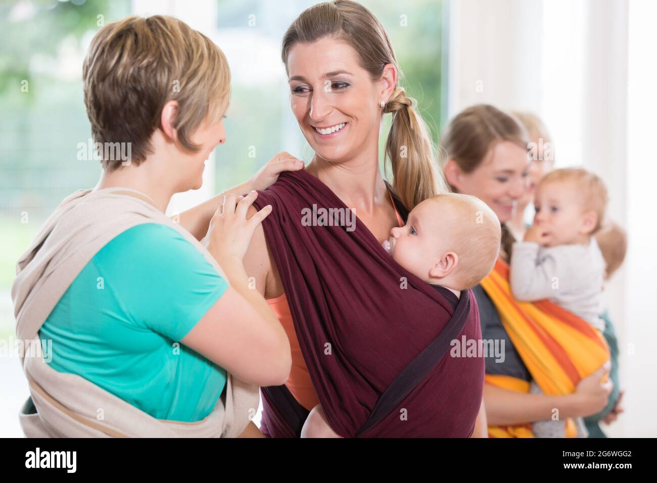 Group of women learning how to use baby slings for motherchild bonding