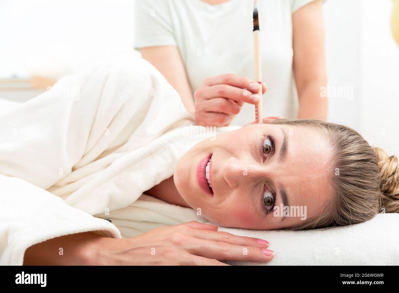 Close up of woman's head with burning ear candle Stock Photo Alamy
