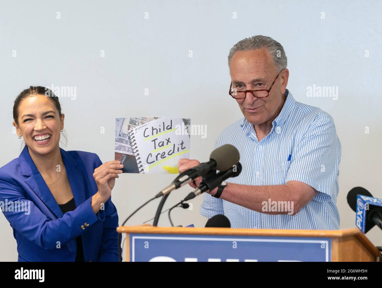 New York, NY - July 8, 2021: Senate Majority Leader U. S. Senator Charles Schumer and Congresswoman Alexandria Ocasio-COrtez hold photo illistration during press conference on expanded Child Tax Credit (CTC) at Ted Weiss Federal Building Stock Photo