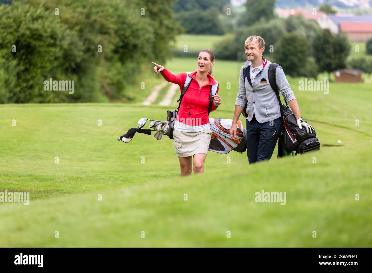 Man looking at her girlfriend pointing something on golf course Stock Photo