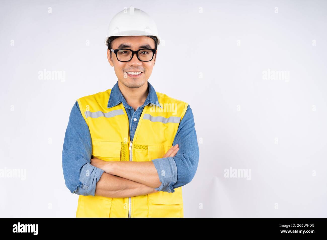 Smiling young asian civil engineer wearing helmet hard hat standing on ...