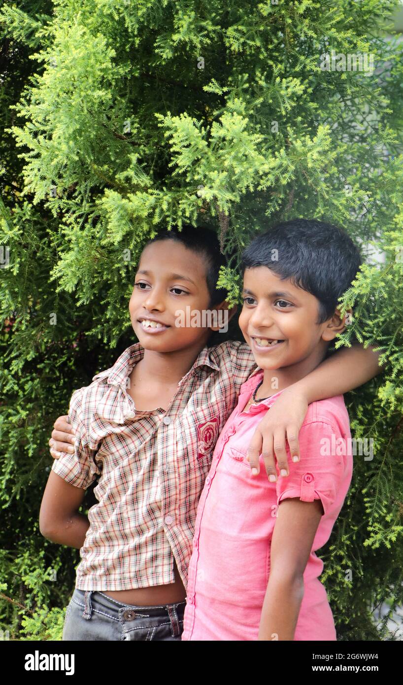 candid photography of two boys who are friends standing with hand on each others shoulders Stock Photo