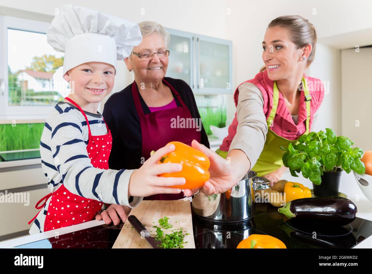 Granny, mum and son talking while cooking in kitchen Stock Photo - Alamy