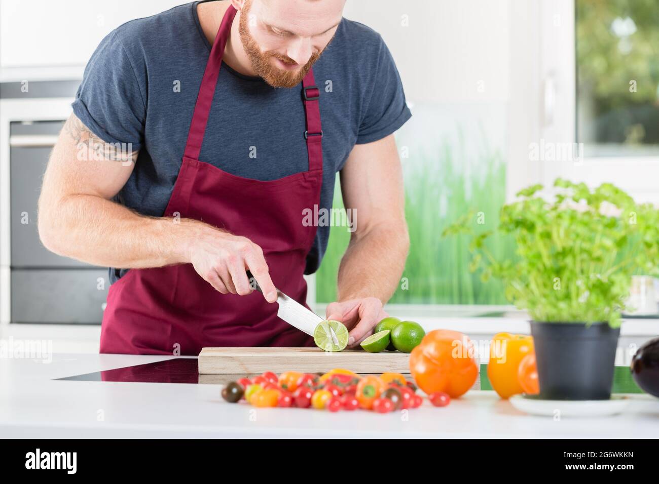 Man preparing veggies for cooking in kitchen Stock Photo