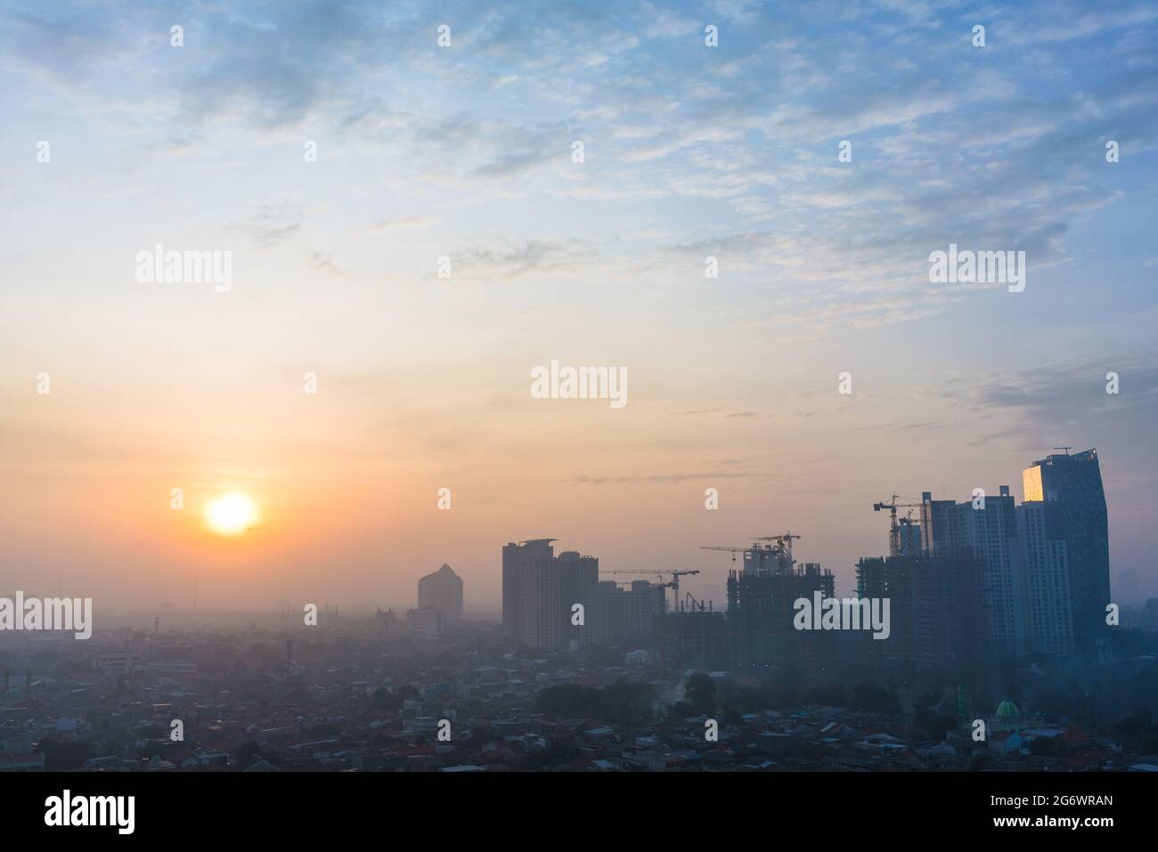 Panoramic view of Jakarta cityscape with skyscrapers and buildings under construction at sunrise Stock Photo