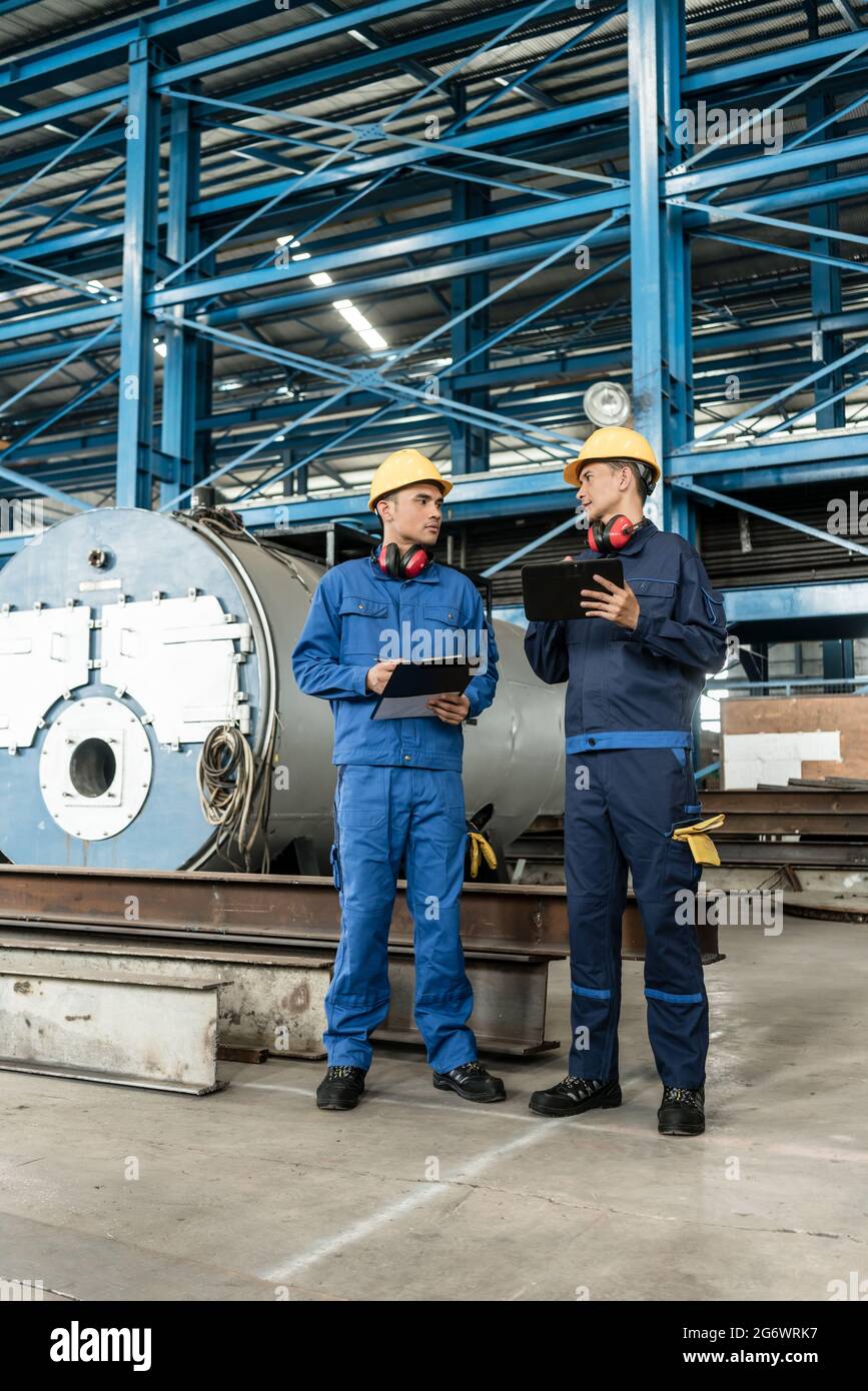 Two Asian experts checking information during quality control in the ...