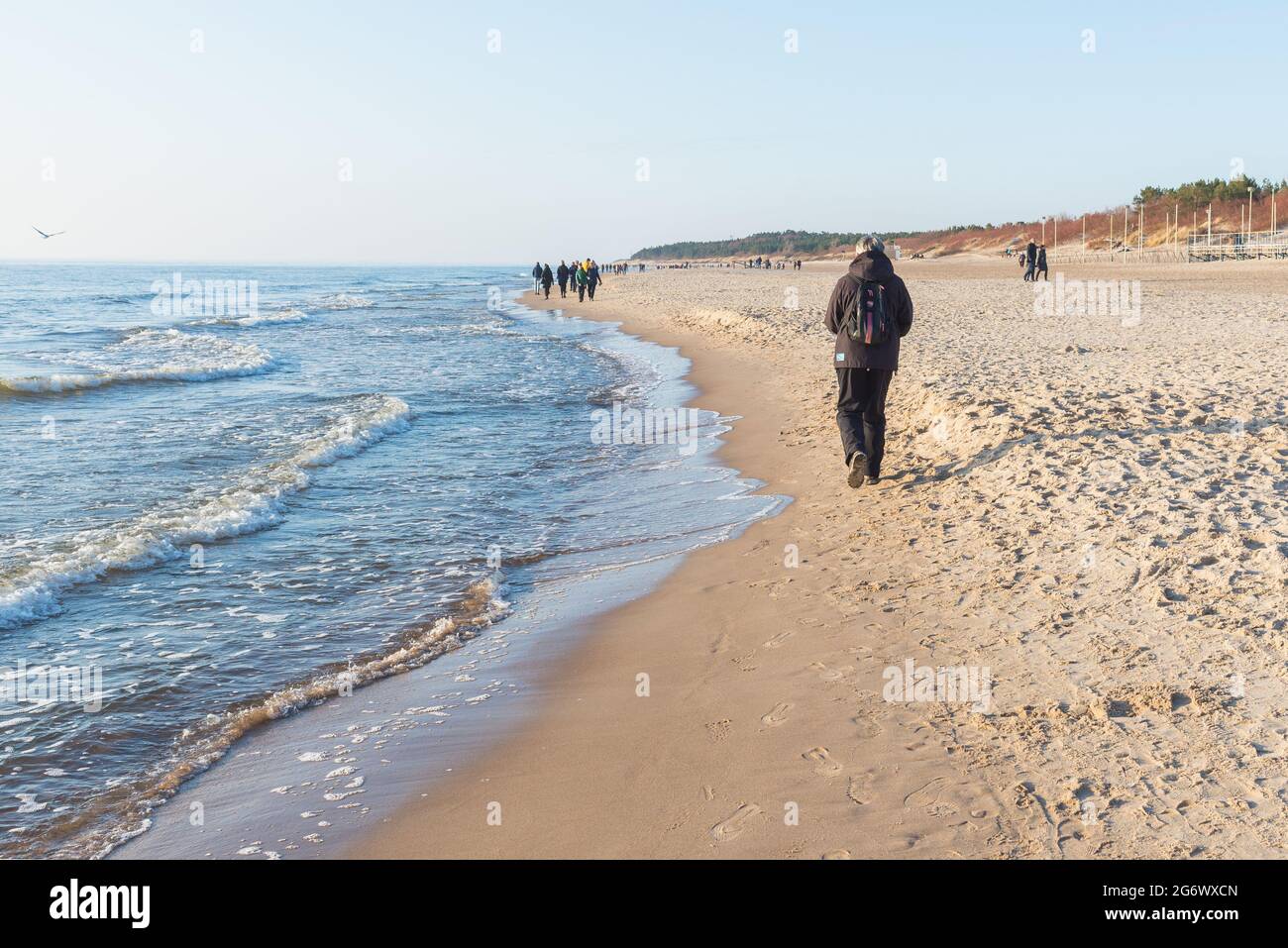 One female traveler with a backpack on the beach in spring when it is still cold.Palanga,Lthuania 28,04,2021 Stock Photo