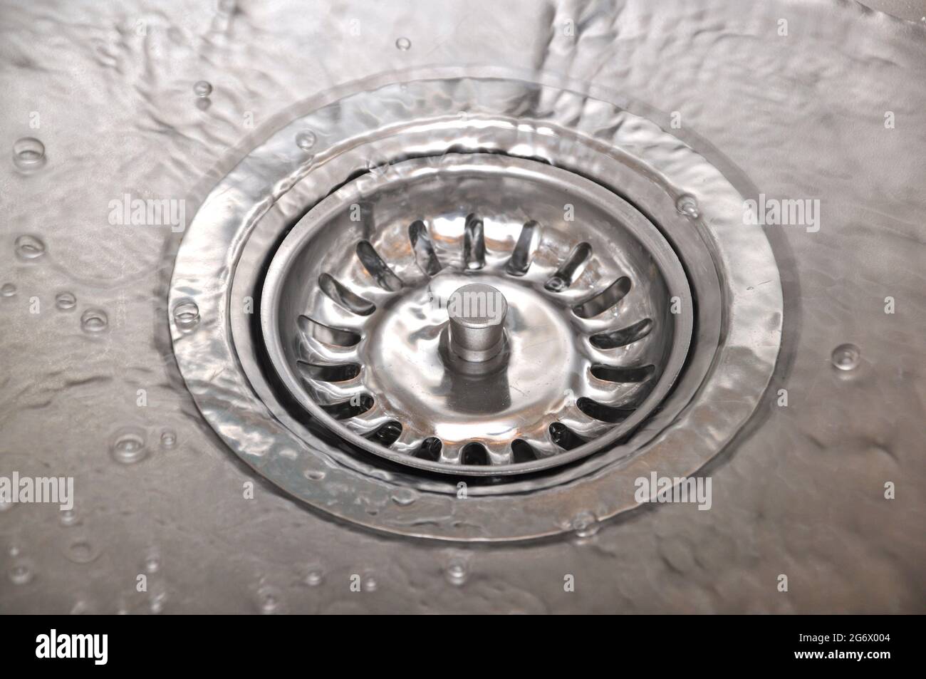 Stainless steel sink and water drain in a modern kitchen, water flow in