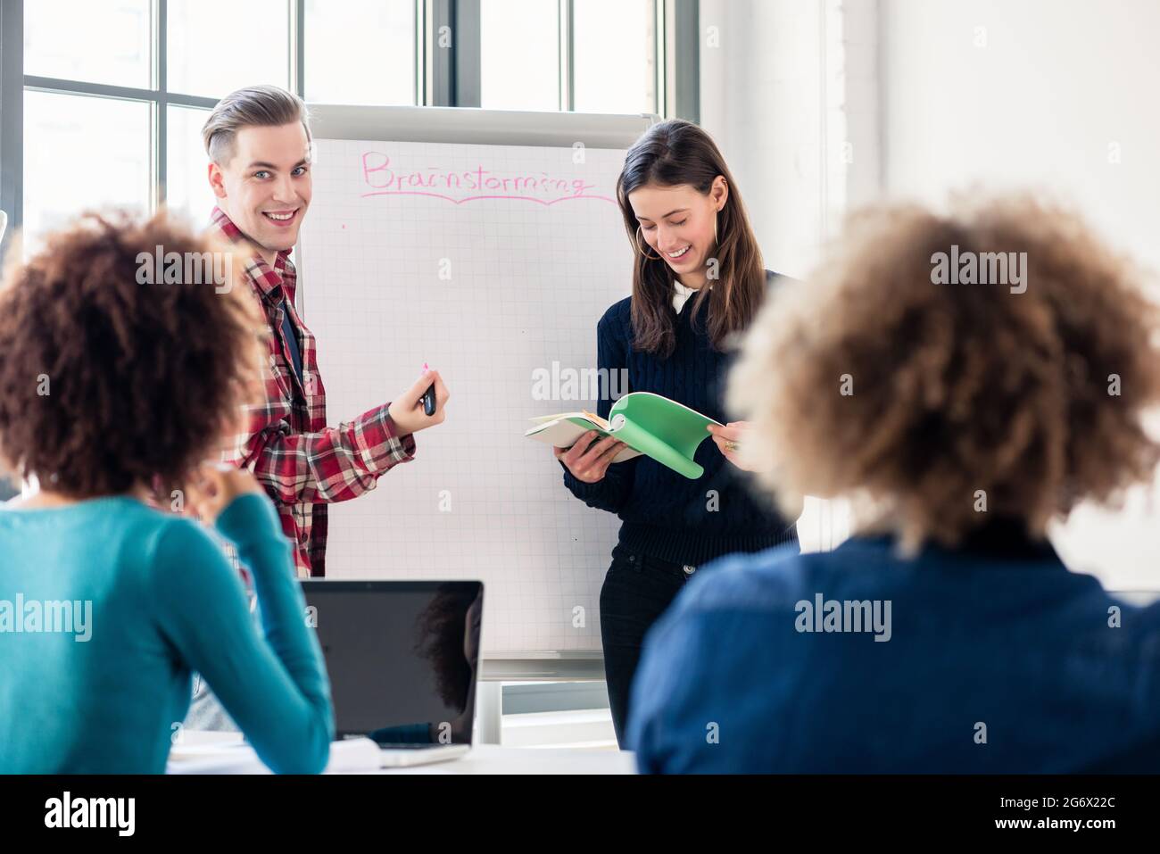 Involved students sharing ideas and opinions while brainstorming during an interactive class in the classroom of a modern college or university Stock Photo